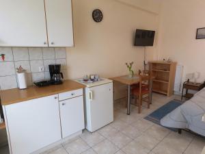 a kitchen with white cabinets and a small table at Flo's Apartments in Missolonghi