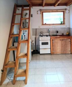cocina con escalera de madera en una habitación en La Cantonada en Caviahue