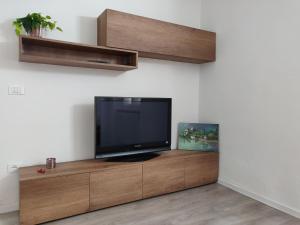 a flat screen tv sitting on top of a wooden entertainment center at La finestra sul Brenta in Lasino