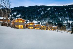 a lodge in the snow with a field of snow at Arlberg Chalets in Wald am Arlberg