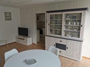 a room with a table and a tv and a kitchen at Bungalow Ulf in Lauchhammer