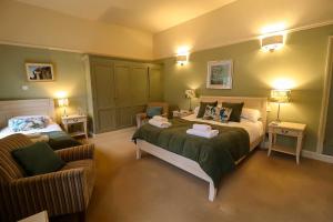 een slaapkamer met een bed en 2 stoelen. bij The Castle Hotel in Bishops Castle