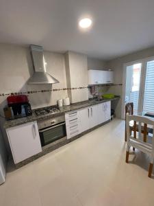 a kitchen with white cabinets and a stove top oven at Sweet Home Alicante in Alicante