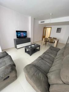 uma sala de estar com um sofá e uma televisão de ecrã plano em Sweet Home Alicante em Alicante