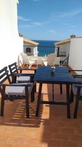 een patio met een tafel en stoelen en de oceaan bij La casita de la playa in Gran Alacant