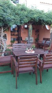 a wooden table and benches in a garden at La casita de la playa in Gran Alacant