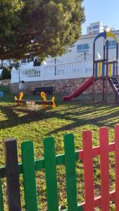 a playground with a colorful fence in a park at La casita de la playa in Gran Alacant