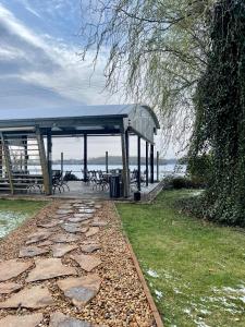 a pavilion with a stone walkway next to the water at Divá Kačica Restaurant & Pansion in Komárno