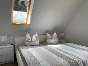 a bedroom with a bed with pillows and a window at Ferienwohnung Familie Görtler in Graal-Müritz