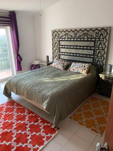 a bedroom with a large bed and a red rug at Villa Vale Grande in Tavira +42 photos