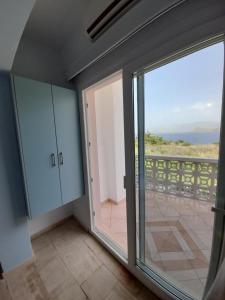 a room with a sliding glass door and a balcony at Avra Studios in Masouri
