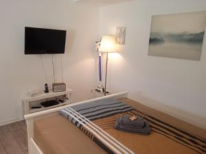 1 dormitorio con 1 cama y TV de pantalla plana en Ferienwohnung Jansen "Drei" en Bad Schwalbach