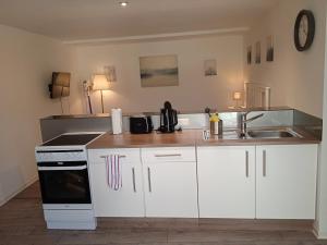 a kitchen with white cabinets and a sink at Ferienwohnung Jansen "Drei" in Bad Schwalbach