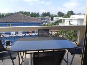 a blue table on a balcony with a view at Апартамент в Керамоти in Keramoti