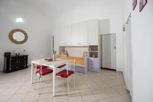 a kitchen with a table and chairs and a refrigerator at Il Riccio Apartment 28 in Procida