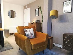 ein Wohnzimmer mit einem Stuhl und einem Spiegel in der Unterkunft Executive Apartment nr NEC, BHX, Resorts World in Hampton in Arden
