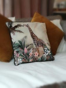 a pillow with a giraffe on it on a bed at Executive Apartment nr NEC, BHX, Resorts World in Hampton in Arden