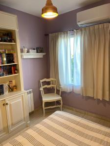 1 dormitorio con silla y ventana en Departamento Nuevo en Cipolletti en Cipolletti