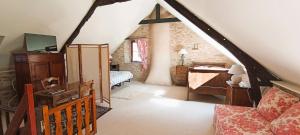 a attic room with a bedroom with a bed and a desk at Longère briéronne 15 mn de La Baule in Saint-Lyphard +9 photos