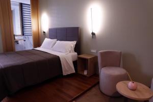 a hotel room with a bed and a chair at Manhattan Room & Suite in Bari