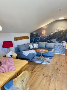 a living room with a blue couch and a table at Allgäu-Moni in Füssen