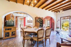 comedor con mesa, sillas y TV en Angela Country House, en Mármaron