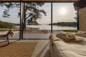 a bedroom with a bed and a view of a lake at Käringsund Resort in Eckerö