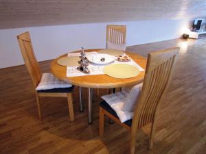 a dining room table with chairs and a toy ship on it at Studio Bergblick in Mellau