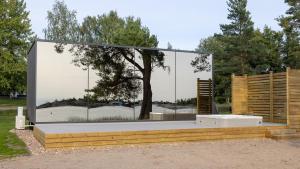 Käringsund Resort في إكيرو: جدار زجاجي كبير وبه شجرة