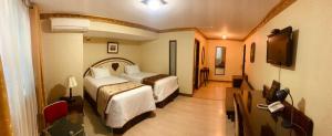 Habitación de hotel con 2 camas y TV de pantalla plana. en Hotel Oro Inn, en Lima