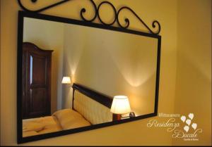 a mirror hanging on a wall in a bedroom at Residenza Ducale in Bovino