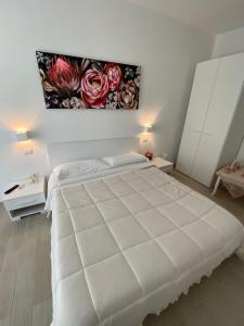um quarto com uma grande cama branca com um quadro na parede em Bed and Breakfast Il Limone em San Pasquale