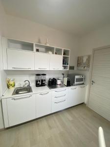 a white kitchen with a sink and a microwave at Bed and Breakfast Il Limone in San Pasquale +18 photos