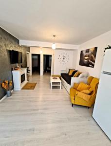 a living room with a yellow couch and a tv at Relax Apartment Predeal in Predeal