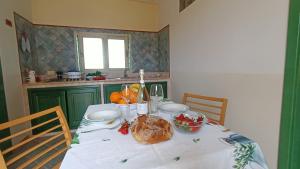a table with a loaf of bread and fruit on it at La Casa Dei Delfini in Lampedusa