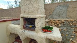 a stone oven with a plate of tomatoes on a table at La Casa Dei Delfini in Lampedusa
