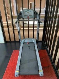 a treadmill sitting on a red rug next to a fence at Grandview 312 - 1BR Condo Near Burnham Park in Baguio