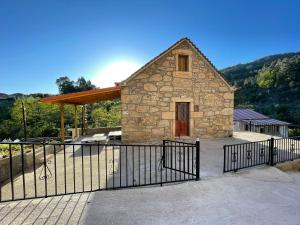 a stone building with a gate in front of it at Casa 2 Gallos in Ourense