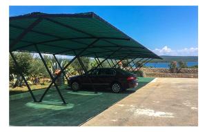 a car parked under a large green canopy at Vila s bazenom Mavrinac in Nerezine
