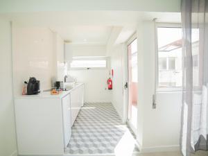 a kitchen with white cabinets and a tile floor at CM Vintage Apartments in Porto