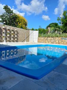 uma piscina com um coping azul em um quintal em Pousada Pedra do Sossego em Triunfo
