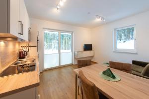 een keuken en eetkamer met een houten tafel in een kamer bij Feichtingerbauer in Fuschl am See