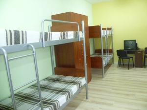 a room with two bunk beds and a desk at Hostel Vitan in Lviv