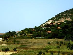 Une colline avec des maisons au sommet d'un champ verdoyant dans l'établissement Villa Mukaj, à Fratar
