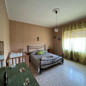 1 dormitorio con 1 cama y 2 mesas. en LE RADICI, en Civitella dʼAgliano