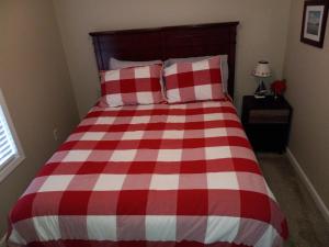 a red and white checkered bed in a bedroom at Cabin by the lake in Burnside
