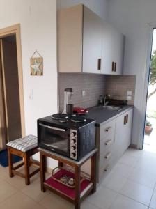 een keuken met een fornuis en een wastafel. bij Glyfada Suite in Kastraki Naxou