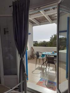een patio met een tafel en stoelen op een balkon bij Glyfada Suite in Kastraki Naxou
