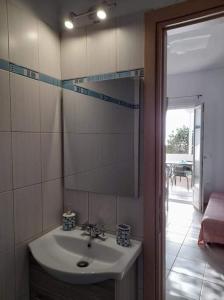a bathroom with a sink and a mirror at Glyfada Suite in Kastraki Naxou
