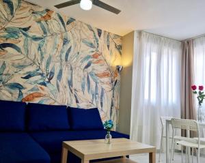 sala de estar con sofá azul y pared colorida en El Oasis de SteraM Flats Torremolinos, en Torremolinos
